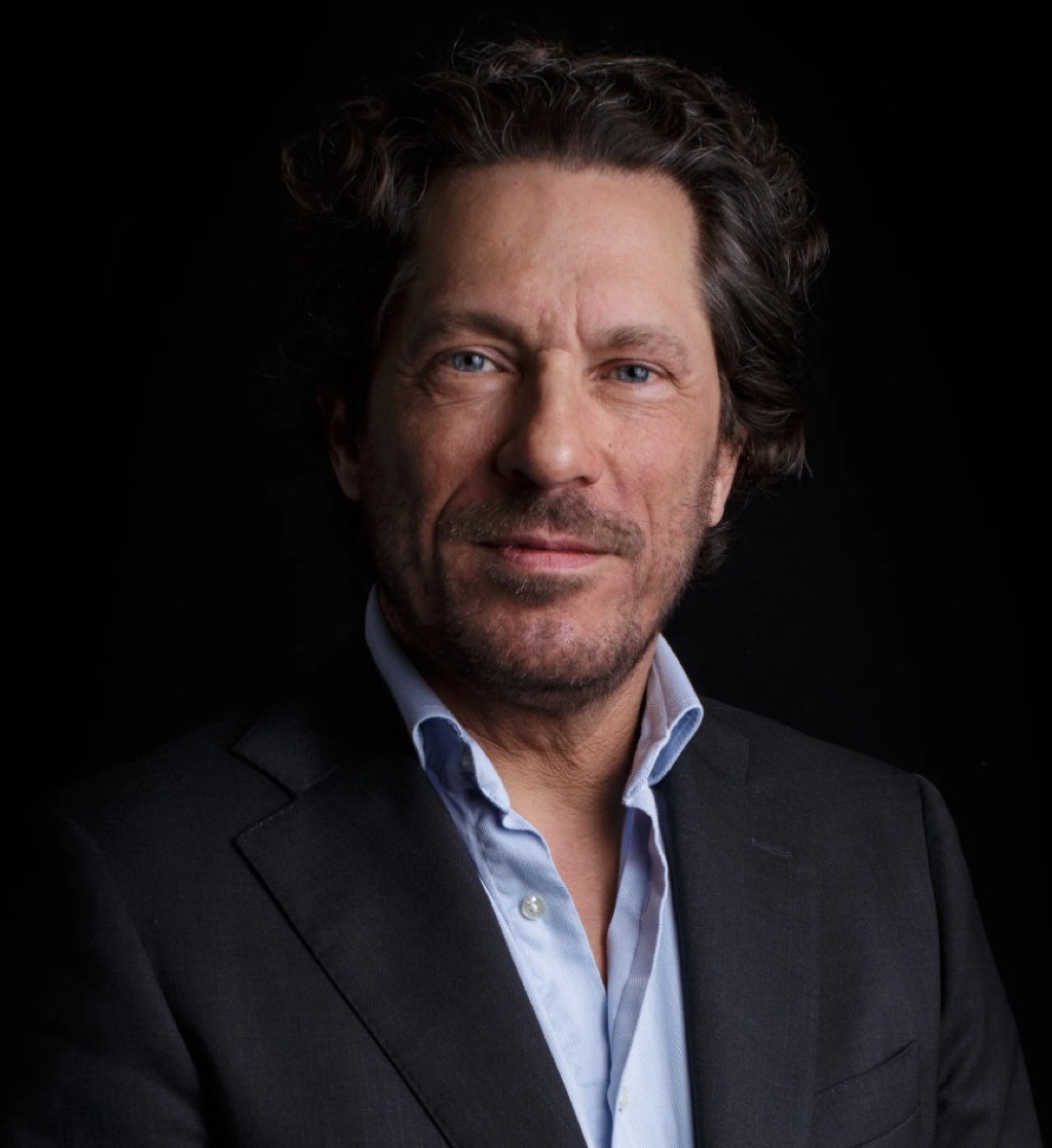 Low-key studio portret man in donker colbert — LinkedIn profielfoto Den Haag