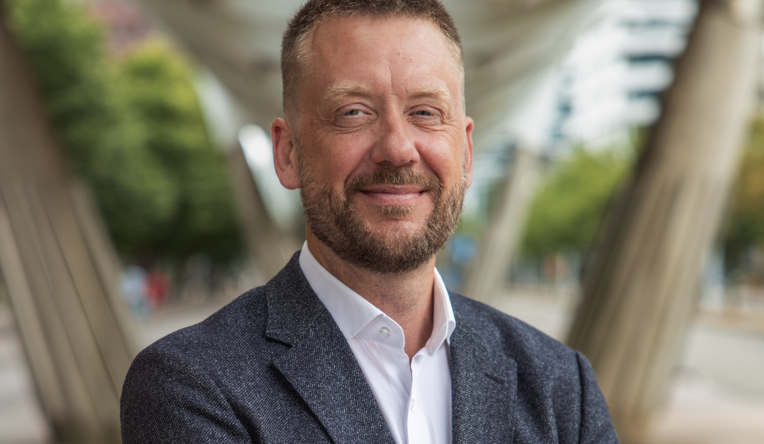 Zakelijk CEO-portret op locatie, man in donker pak bij raam